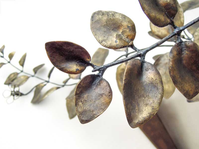 厚みのあるステンレス板の隙間からツルニチニチソウが伸びている様子を鍛鉄で表現したアート作品、葉のアップ。花はワイヤーワーク表現で葉はソリッド表現になっています。