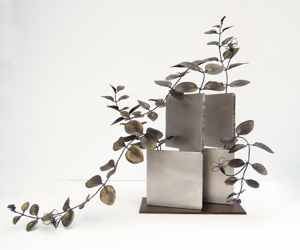 厚みのあるステンレス板の隙間からツルニチニチソウが伸びている様子を鍛鉄で表現したアート作品。花はワイヤーワークになっています。