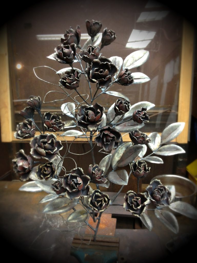 アイアンアートのバラ。小さな鉄の花びらのパーツを鍛造してまとめて花を作っています。面表現の葉と線表現の葉を混ぜることで軽やかな印象になるようまとめています。