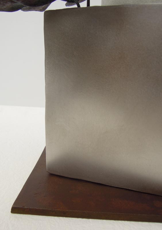 厚みのあるステンレス板の隙間からツルニチニチソウが伸びている様子を鍛鉄で表現したアート作品、ベースのアップ。上品に磨いたステンレス板の柔らかい光沢と、鋳造真鍮板をお歯黒で渋めに染めた色味の対比。