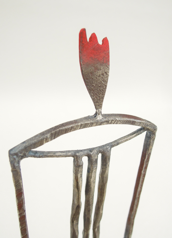 鉄で出来ている椅子のオブジェ。スタイリッシュなハイバックデザイン。卓上サイズながら繊細に作りこまれたディテール。トップ付いた小さな翼のアップ写真。岩絵の具で着彩されています。
