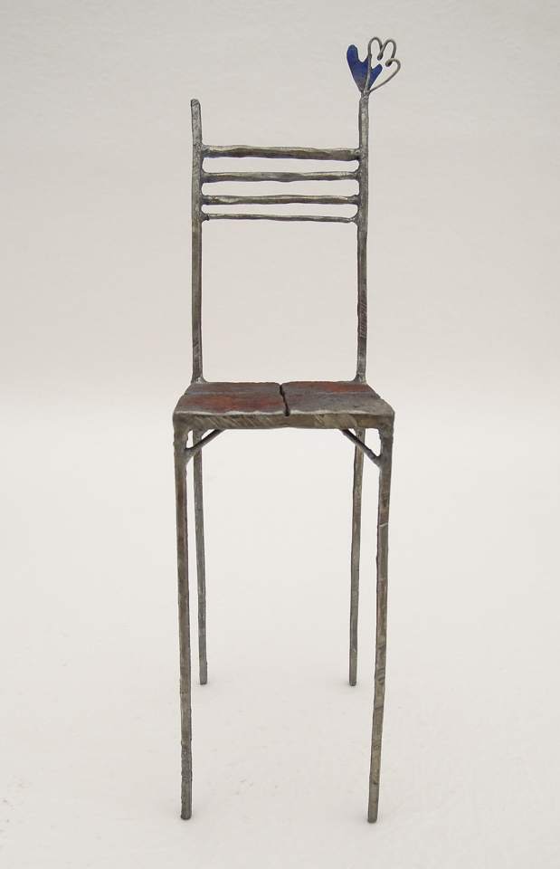 鉄で出来ている椅子のオブジェ。スタイリッシュなハイバックデザイン。卓上サイズながら繊細に作りこまれたディテール。トップに小さな翼が付いています。正面からの写真。