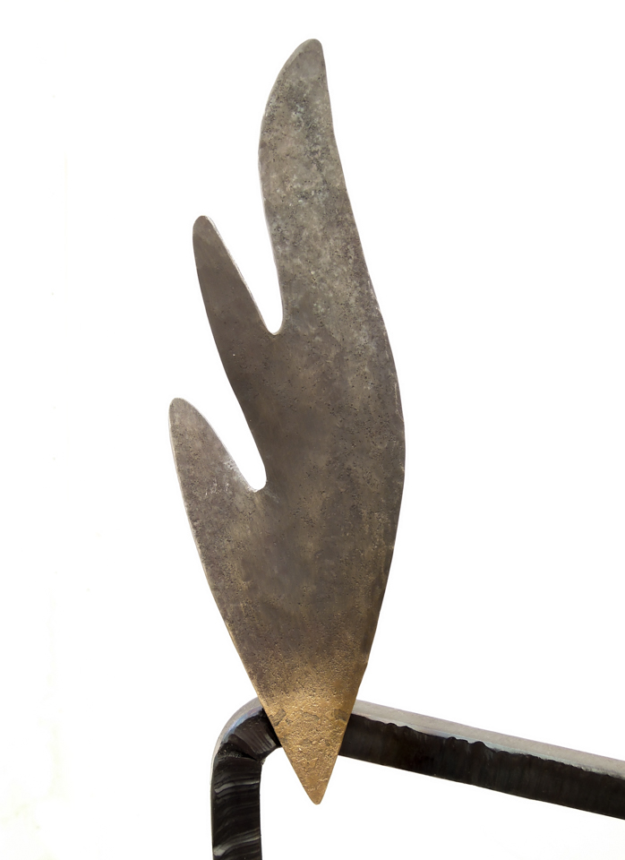 鉄で出来ている実際に座れる椅子のオブジェ。シンプルな背のデザインと、トップの翼と右側に着いた飾りが特徴的です。 翼の写真。叩き出した柔らかい曲面です。