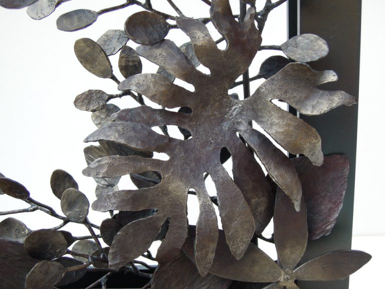 四角い窓から様々な植物が溢れでているようなアートオブジェです。鉄で作られたフィロデンドロン・タンゴの葉ののアップ。部分写真。