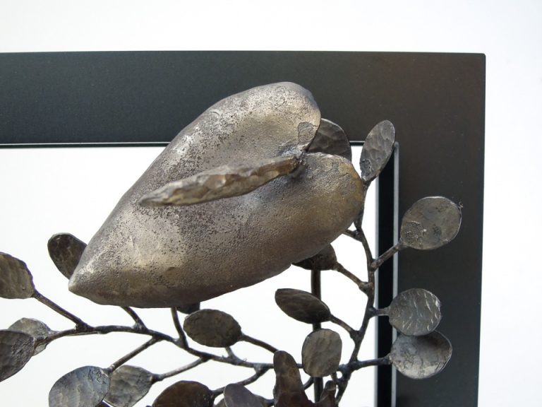 四角い窓から様々な植物が溢れでているようなアートオブジェです。鉄で作られたストレリチアのアップ。部分写真。