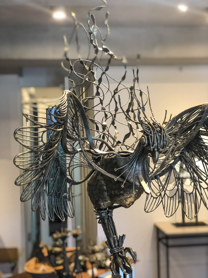 鍛鉄で伝説の生物を制作した幻想的鉄生物 L-Febシリーズ「鳳凰＿鳳」個展会場での写真。ハロゲンライトに照らされ、細部まで綺麗に見えています。撮影 横山沙布