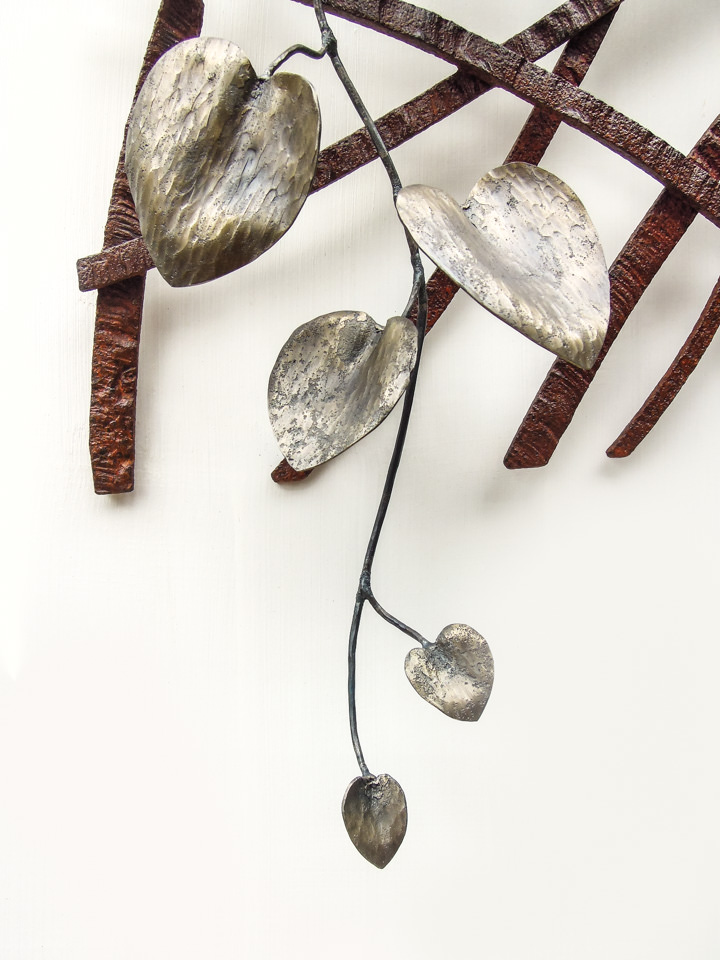 風の流れを模したラインにカンガルーアイビーが寄り添う鍛鉄アートの作品です。葉の写真。