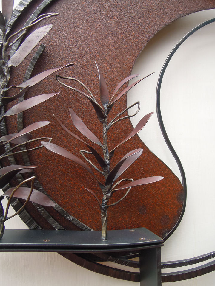 勢いよく伸びるオリーブの枝を鉄で表現した壁面アート作品です。葉は面と線の表現を混在させ、背景に円を切り欠いた面を配置しました。オリーブの部分写真。