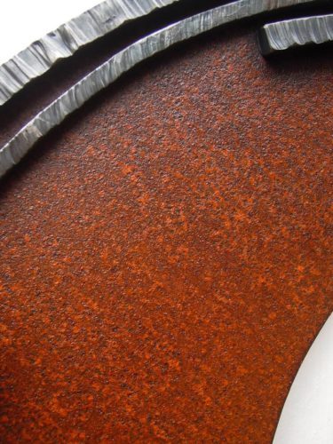 勢いよく伸びるオリーブの枝を鉄で表現した壁面アート作品です。葉は面と線の表現を混在させ、背景に円を切り欠いた面を配置しました。背景部分の写真。