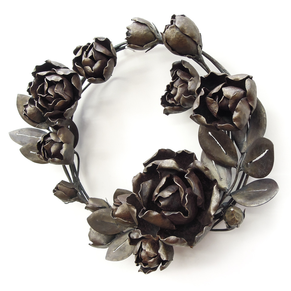 バラの花を溢れるように配置した鍛鉄のリースです。固い蕾から綻びかけたもの、大きく咲き誇るもの、様々な段階のバラをリズミカルにつなげました。全体写真。