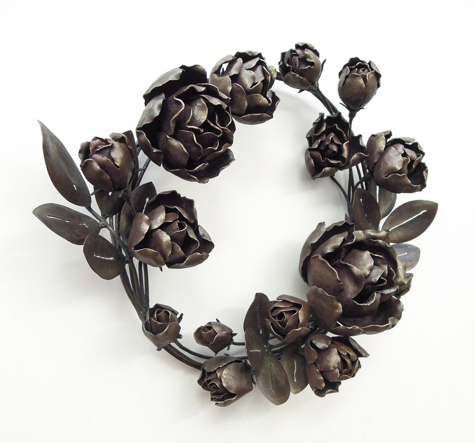 バラの花を溢れるように配置した鍛鉄のリースです。固い蕾から綻びかけたもの、大きく咲き誇るもの、様々な段階のバラをリズミカルにつなげました。全体写真。