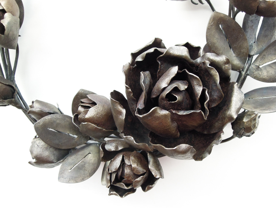 バラの花を溢れるように配置した鍛鉄のリースです。咲き誇る花の表現。