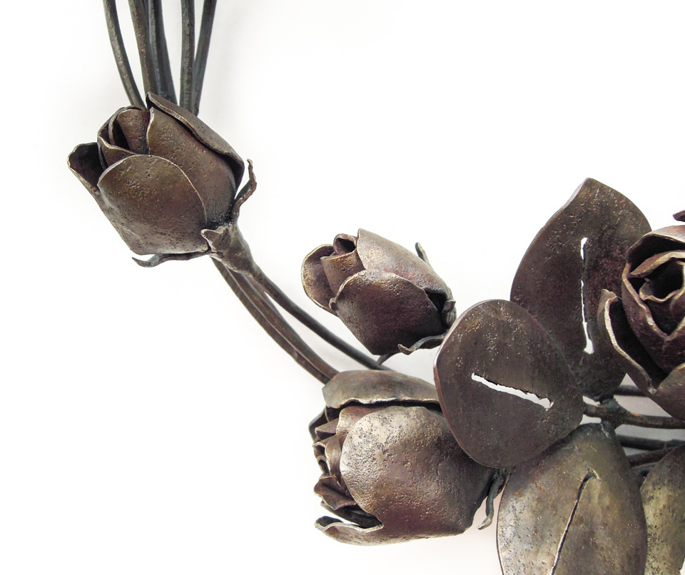 バラの花を溢れるように配置した鍛鉄のリースです。膨らんだ蕾の表現。