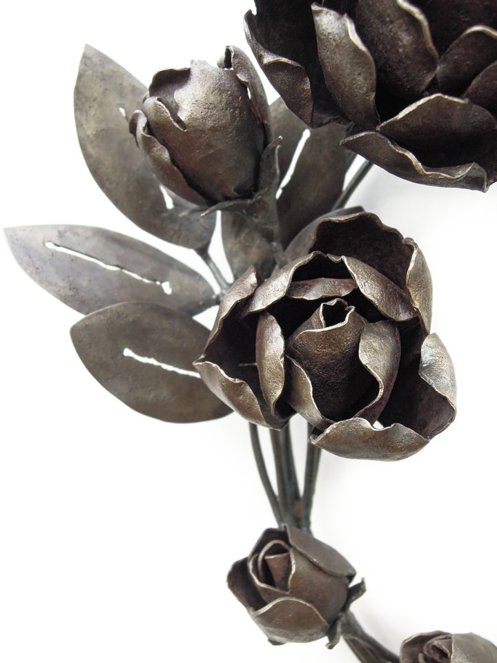 バラの花を溢れるように配置した鍛鉄のリースです。綻び始めた蕾の表現。