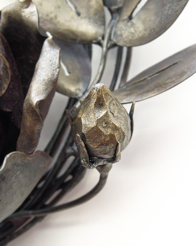 バラの花を溢れるように配置した鍛鉄のリースです。硬く閉じた蕾の表現。