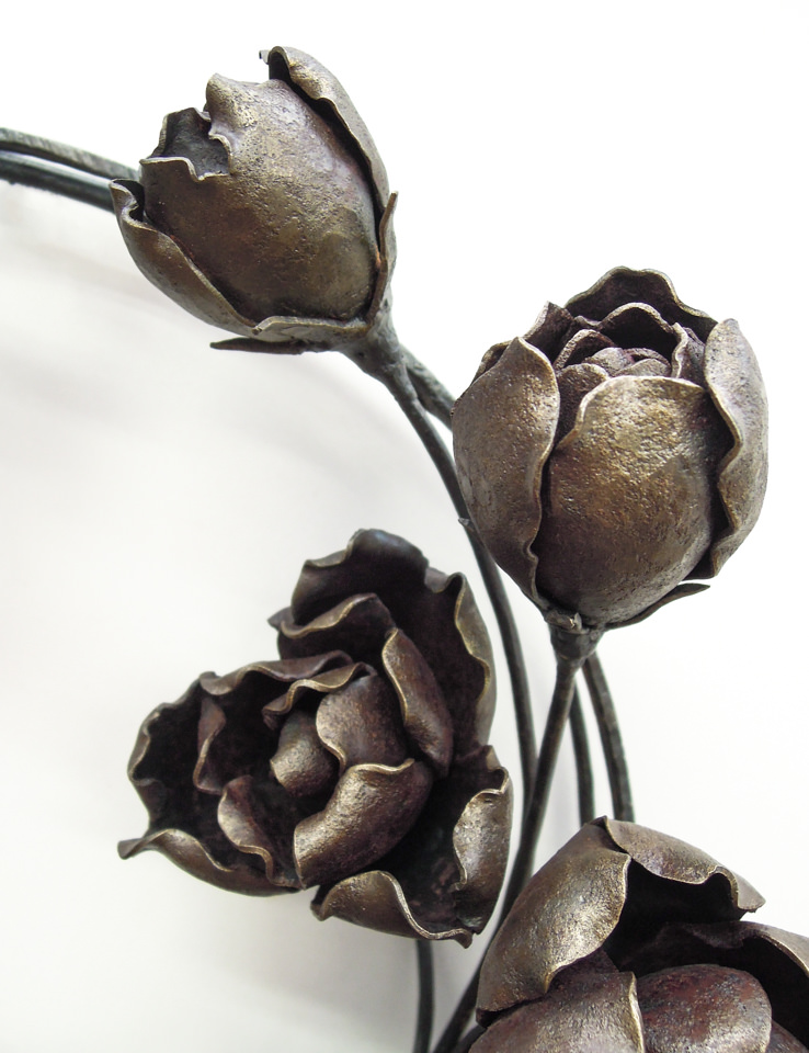 バラの花を溢れるように配置した鍛鉄のリースです。膨らんだ蕾の表現。