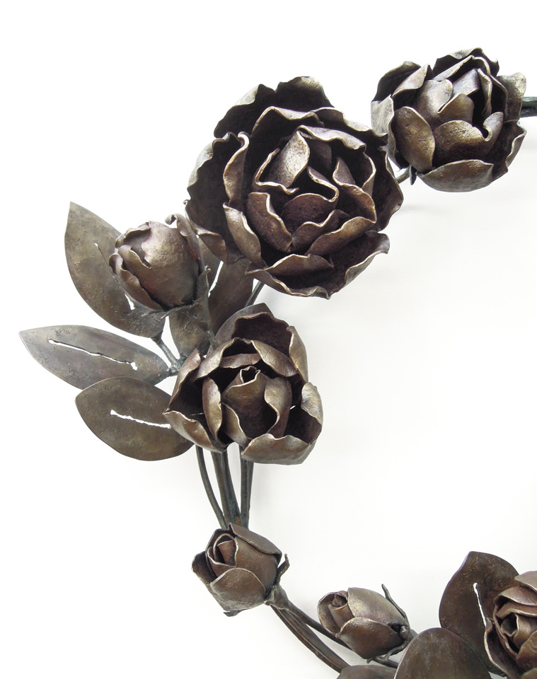 バラの花を溢れるように配置した鍛鉄のリースです。咲き誇る花の表現。