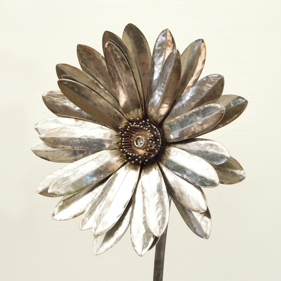 ガーベラの花をモチーフに拡大してステンレスで製作した彫刻です。花弁は熱をかけずに鍛造して形を整えました。顎、花弁、花芯を分解してメンテナスできる仕様になっています。